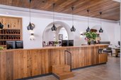 Die stilvolle Rezeption aus warmem Holz und modernen Akzenten im Landgut Furtherwirt lädt zum Einchecken und Wohlfühlen ein