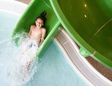 Ein Junge in einer Wasserrutsche kurz vor dem Eintauchen ins Wasser
